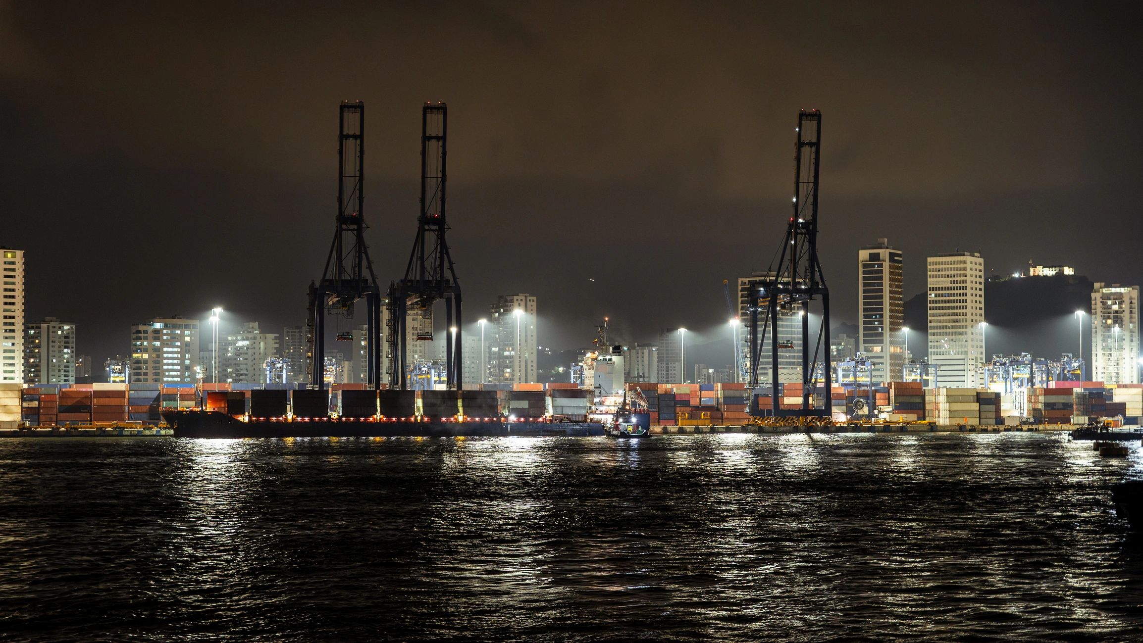 Port terminal with cranes and container ship at night