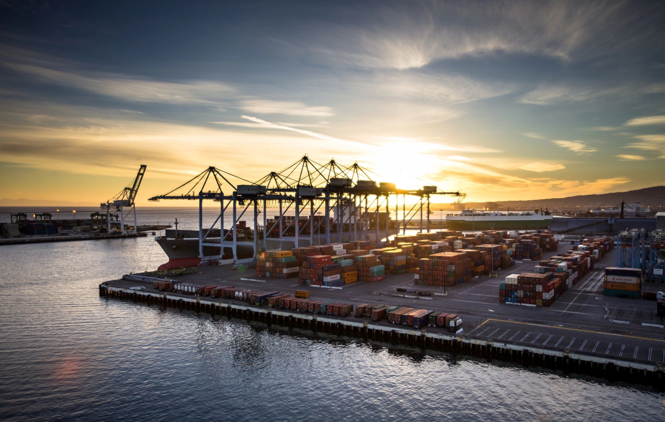 Distant view of a container port and shipping yard at sunset